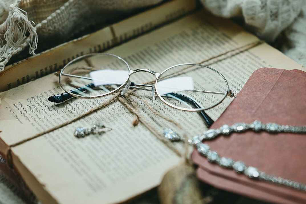 Pile of old books with reading glasses