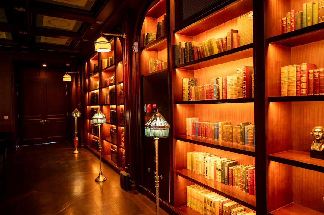 Old library interior with tall bookshelves and warm light