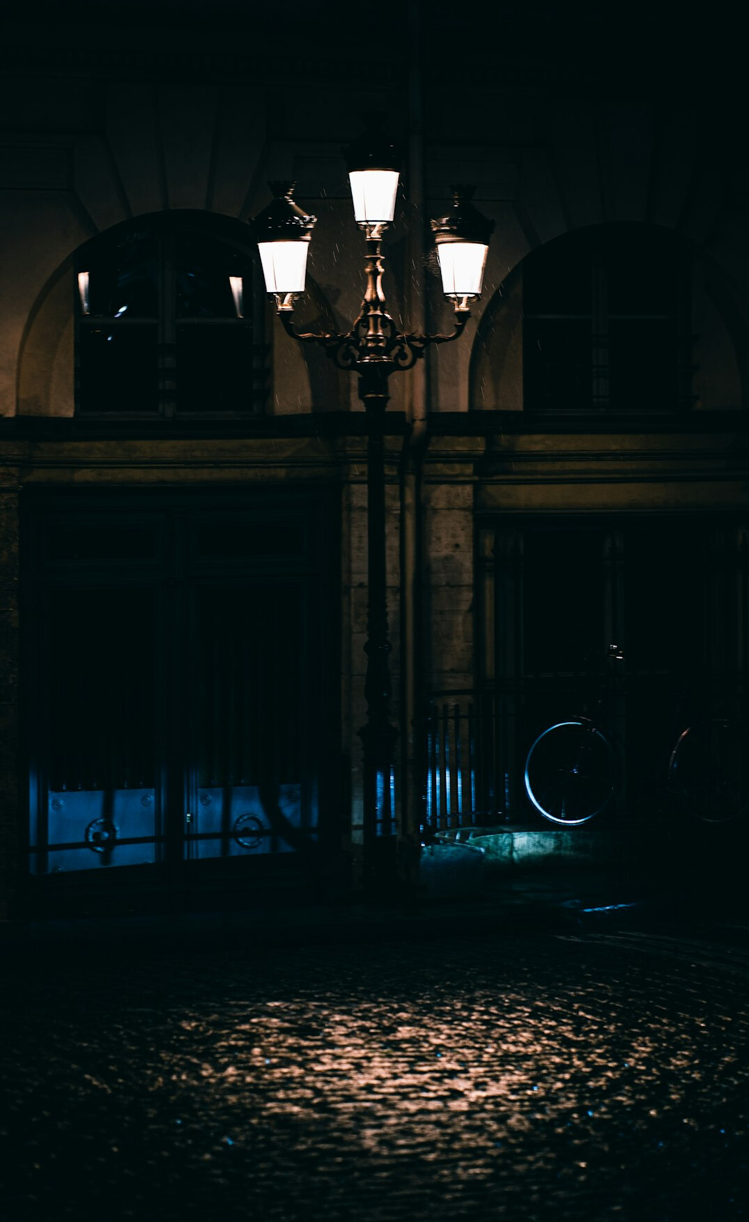 Rainy street at night with streetlamp reflections